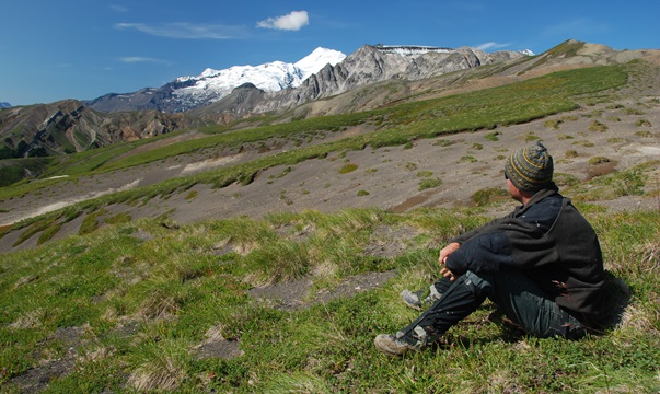 Geologist observes outcrops of West Foreland Formation near Tyonek with Mt. Spurr in the background